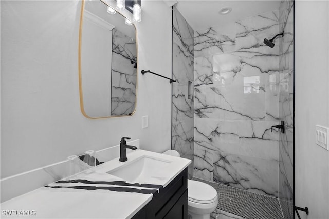 bathroom featuring vanity, toilet, and tiled shower