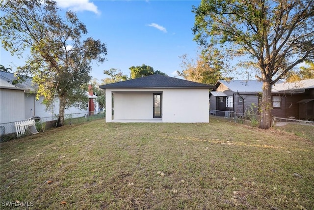 rear view of property featuring a yard