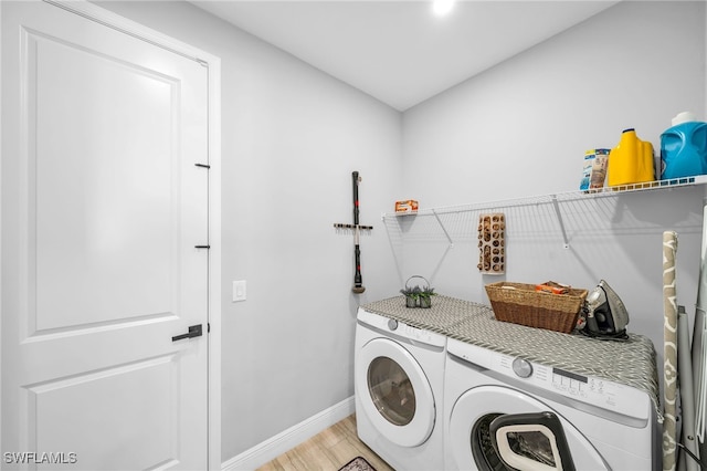 laundry room featuring washer and dryer and light wood-type flooring