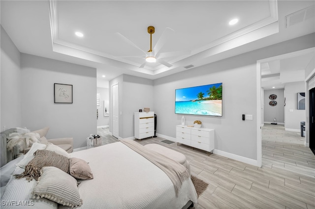 bedroom featuring light wood-type flooring, a raised ceiling, and ceiling fan