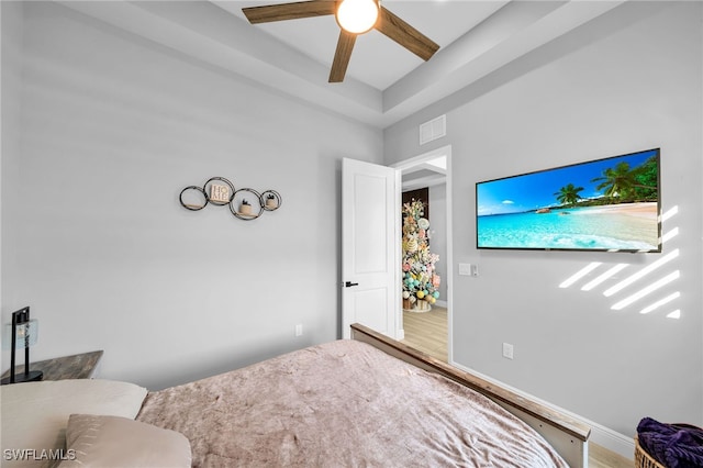 bedroom with hardwood / wood-style flooring, ceiling fan, and beamed ceiling