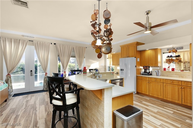 kitchen featuring white fridge with ice dispenser, dishwasher, sink, light hardwood / wood-style floors, and a kitchen island with sink