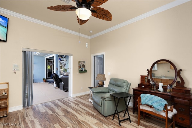 living area featuring ceiling fan, light hardwood / wood-style floors, and crown molding