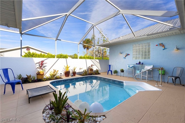 view of pool with a patio and glass enclosure