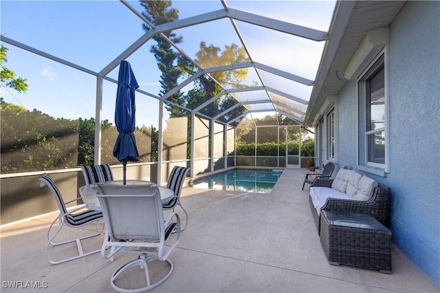 view of pool featuring glass enclosure and a patio