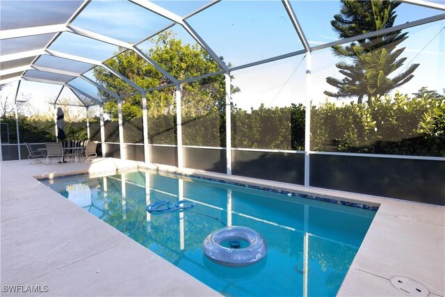 view of swimming pool with glass enclosure and a patio area