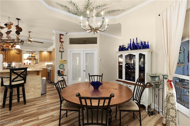 dining room featuring light hardwood / wood-style floors, french doors, crown molding, and a chandelier