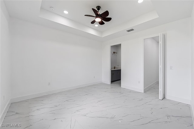 unfurnished room featuring ceiling fan and a tray ceiling