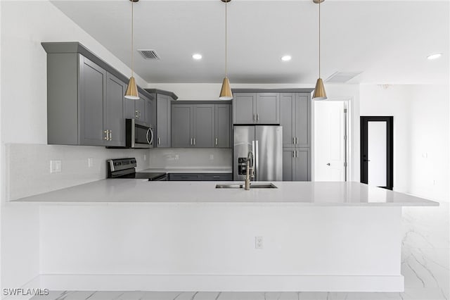 kitchen with pendant lighting, sink, gray cabinets, kitchen peninsula, and stainless steel appliances