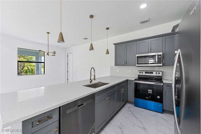 kitchen with kitchen peninsula, hanging light fixtures, stainless steel appliances, and sink