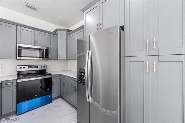 kitchen with appliances with stainless steel finishes and gray cabinets