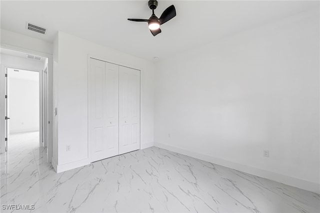 unfurnished bedroom with ceiling fan and a closet