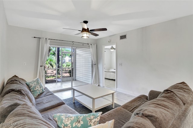 living room with ceiling fan and light hardwood / wood-style flooring