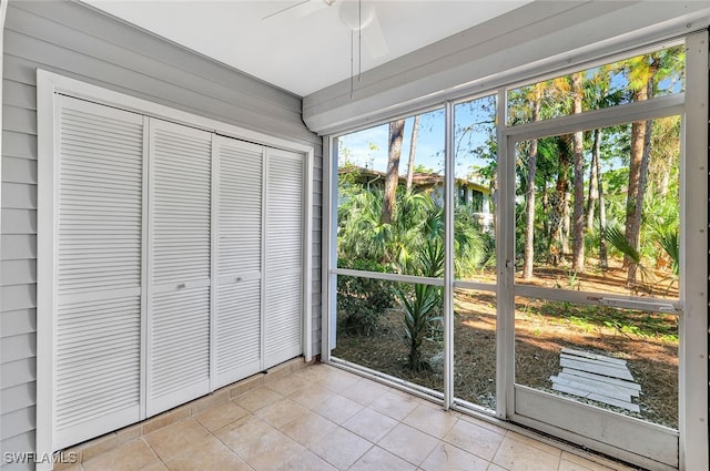 unfurnished sunroom featuring ceiling fan