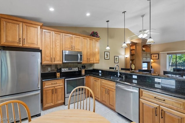 kitchen featuring dark stone counters, sink, stainless steel appliances, and lofted ceiling