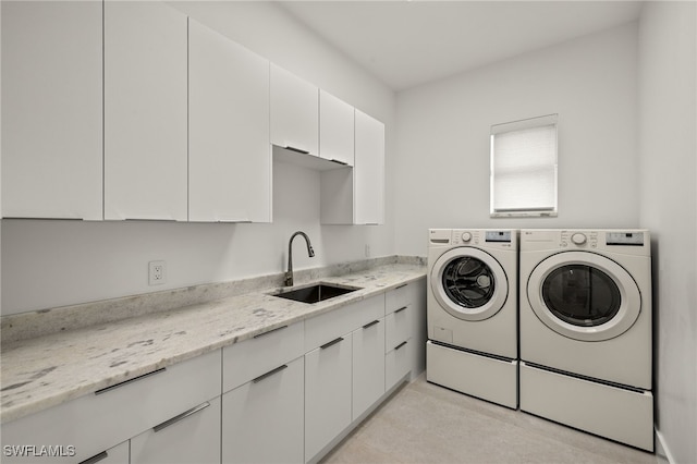 laundry area featuring cabinets, independent washer and dryer, and sink