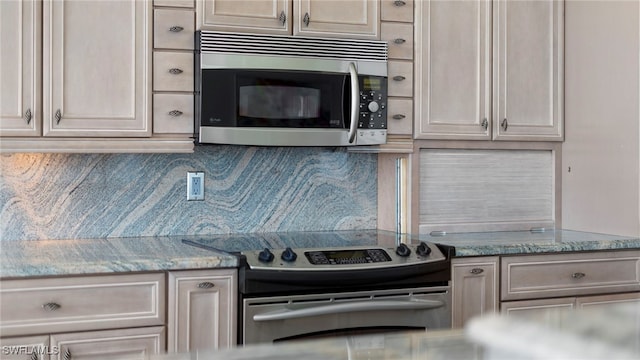 kitchen featuring decorative backsplash, light stone counters, and appliances with stainless steel finishes