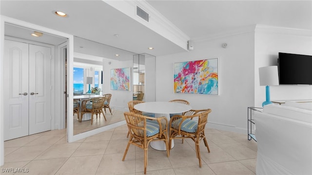 dining area featuring crown molding and light tile patterned floors