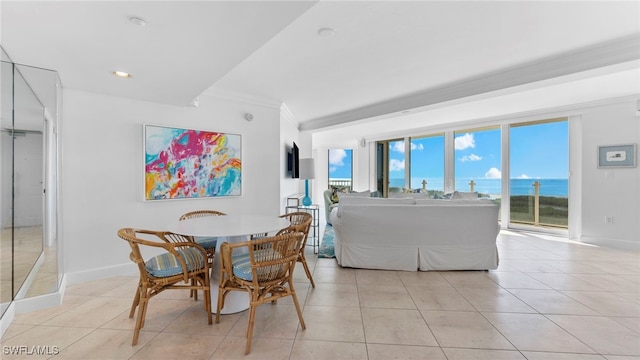 tiled dining space with a water view and ornamental molding