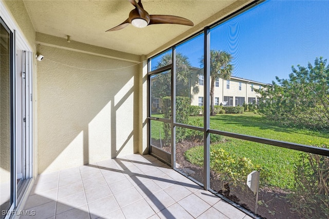 unfurnished sunroom featuring ceiling fan