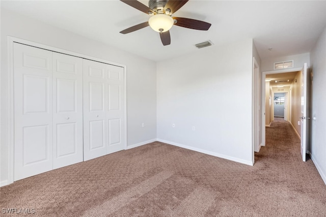 unfurnished bedroom featuring carpet, ceiling fan, and a closet