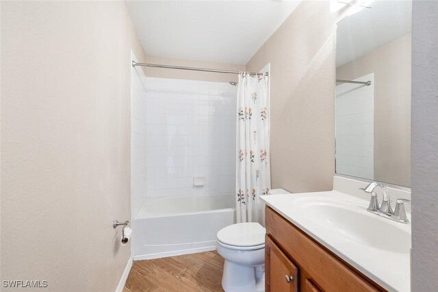 full bathroom featuring hardwood / wood-style floors, vanity, toilet, and shower / tub combo with curtain