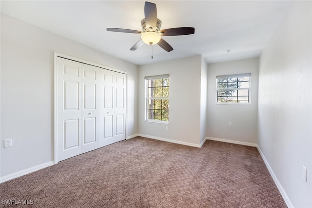 unfurnished bedroom with ceiling fan, a closet, and carpet