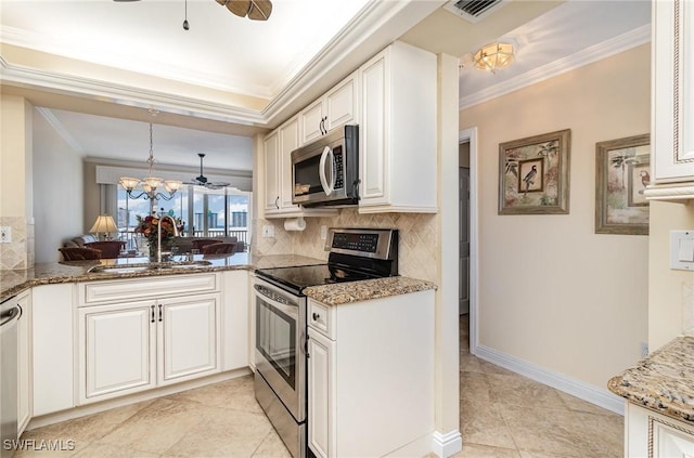 kitchen featuring appliances with stainless steel finishes, white cabinetry, pendant lighting, and dark stone countertops