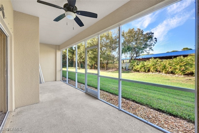 unfurnished sunroom with ceiling fan