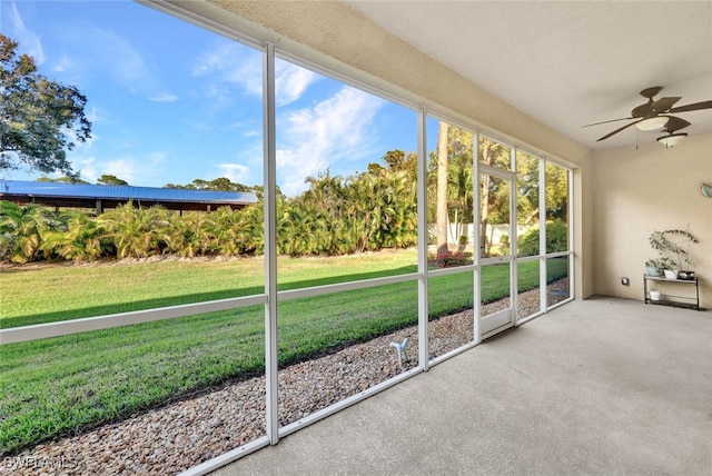 unfurnished sunroom with ceiling fan