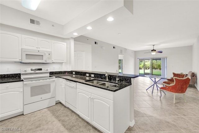 kitchen featuring sink, kitchen peninsula, dark stone counters, white appliances, and white cabinets