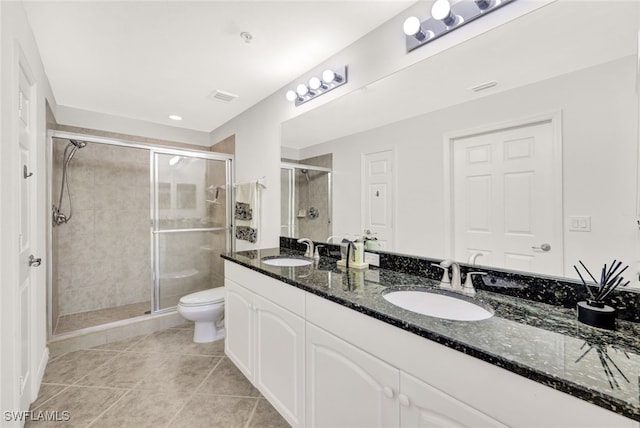 bathroom with tile patterned floors, vanity, an enclosed shower, and toilet