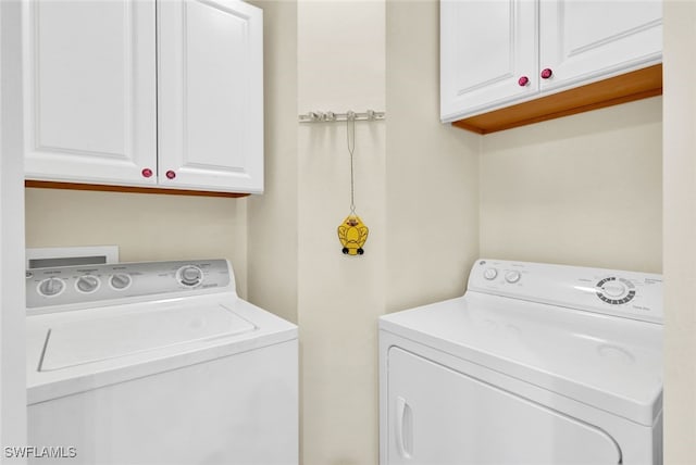 laundry room with cabinets and washing machine and clothes dryer