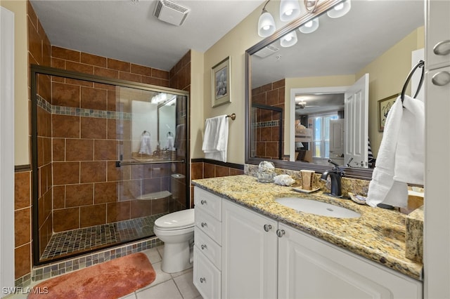 bathroom with tile patterned flooring, vanity, toilet, and walk in shower