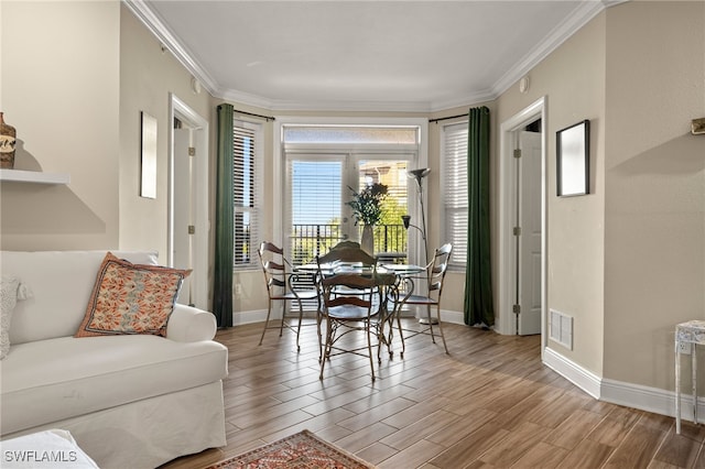 dining space with light hardwood / wood-style floors and crown molding