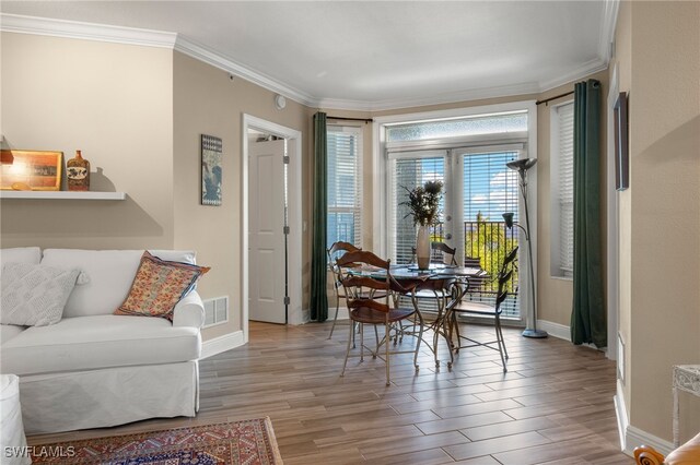 dining room featuring light wood-type flooring and ornamental molding