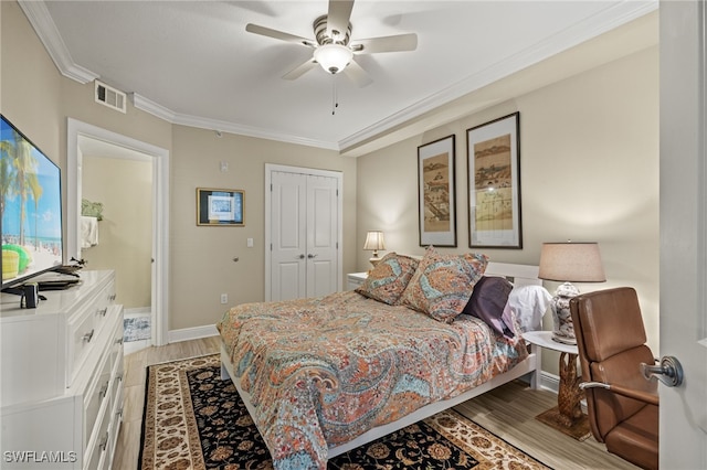 bedroom featuring ceiling fan, light wood-type flooring, crown molding, and a closet