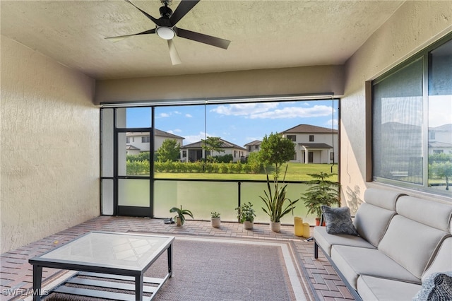 sunroom featuring ceiling fan and a wealth of natural light