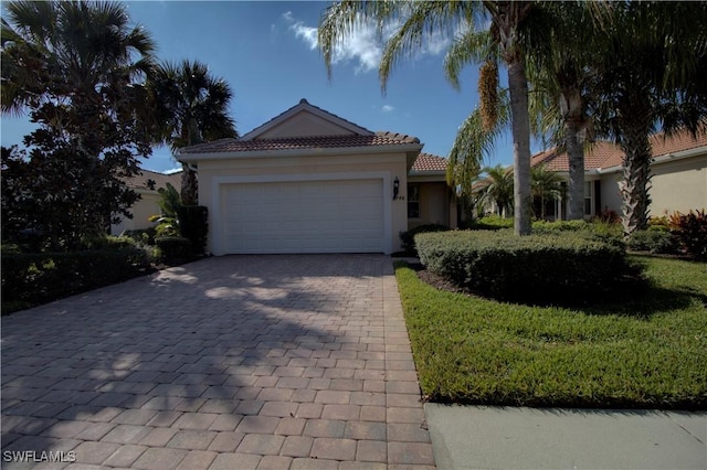 mediterranean / spanish house with a garage and a front lawn