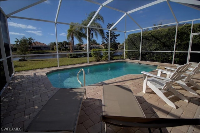 view of pool featuring glass enclosure, a water view, and a patio