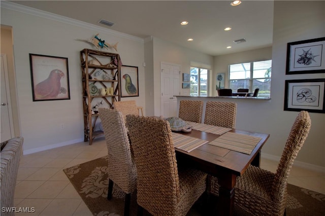 dining space with ornamental molding and light tile patterned floors