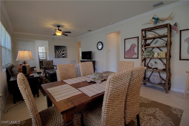 tiled dining area with crown molding and ceiling fan