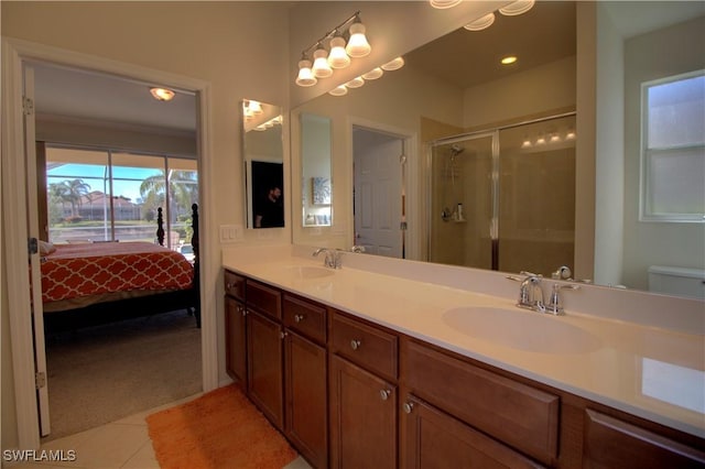 bathroom featuring tile patterned flooring, vanity, toilet, and a shower with door