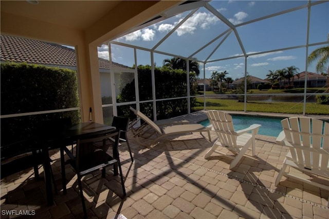 view of patio featuring a water view and a lanai