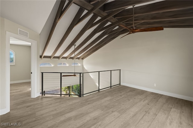 interior space featuring beam ceiling, high vaulted ceiling, and light hardwood / wood-style floors