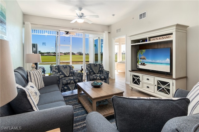 living room with wood-type flooring, plenty of natural light, and ceiling fan