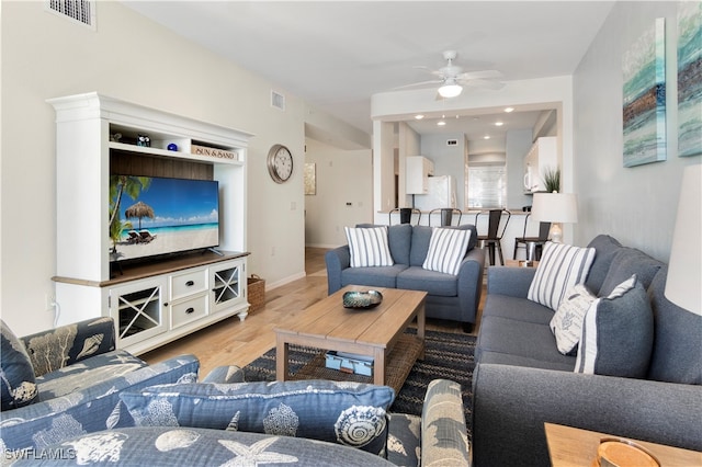 living room with light wood-type flooring and ceiling fan