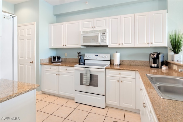 kitchen with white cabinets, white appliances, light tile patterned flooring, and sink