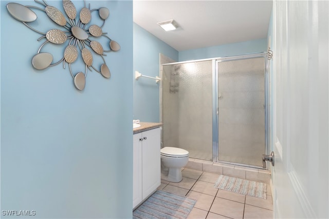 bathroom featuring tile patterned flooring, vanity, toilet, and walk in shower