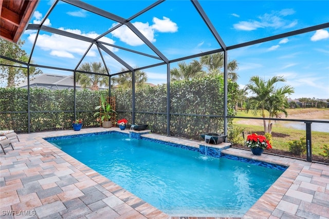 view of pool featuring glass enclosure, pool water feature, and a patio